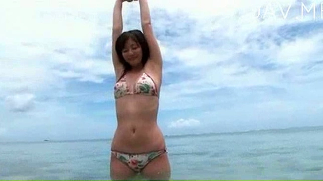 帅气的日本女孩穿着比基尼在海滩上休息。