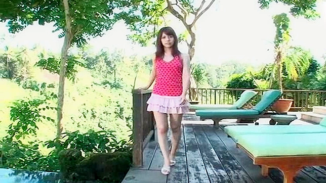 俏皮的亚洲女孩在户外水中展示她的胸部。
